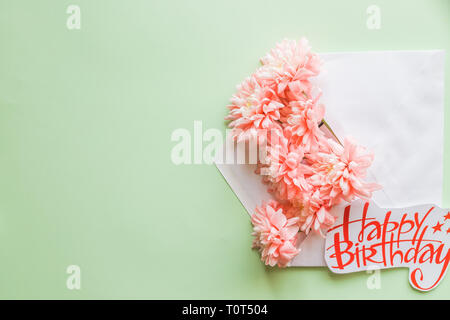 Beautiful floral arrangements. Pink chrysanthemums with envelope on background. Flat lay, top view.Happy Mother's Day Pastel Candy Colors Background. Stock Photo