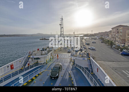 ISOLA MADDALENA, SARDINIA, ITALY - MARCH 7, 2019: Ferry car deck and port area city view with sea promenade near sunset on March 7, 2019 in La Maddale Stock Photo