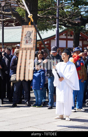 Man dressed in joue Japanese Shinto vestments holding flag on spear at Jigen Memorial Ceremony at Asakusa Shrine near Sensoji Temple, Asakusa, Tokyo. Stock Photo