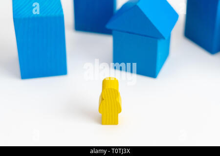 Wooden person on the street of City with wooden blocks houses on the background. Image use for education, insurance or business concept Stock Photo