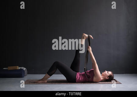 Woman doing Yoga asana Supta padangusthasana or reclining hand to big toe pose Stock Photo