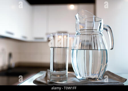 A glass of fresh water with crafin on the background of a modern kitchen. With copy space for your design. Stock Photo