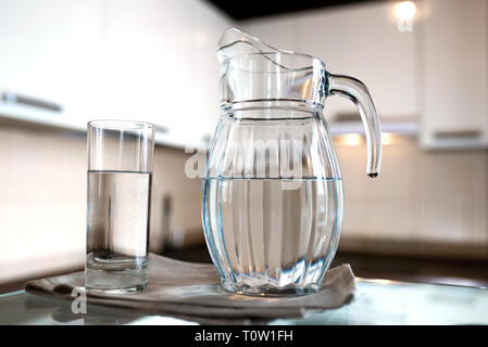 A glass of fresh water with crafin on the background of a modern kitchen. With copy space for your design. Stock Photo