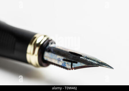 An extreme close-up shot or a macro shot with selective focus of the tip of an inked flexible nib fountain pen. Stock Photo