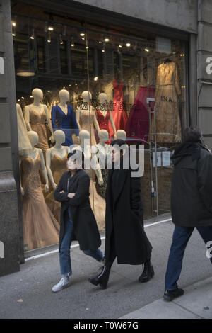 Women walk by a wholesale fashion outlet in the Garment District on the Westside of midtown Manhattan. Stock Photo