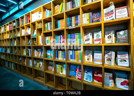 Colorful book shelves packed with books in a library. Stock Photo