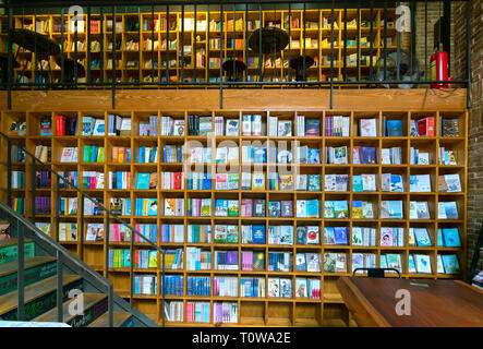 Colorful book shelves packed with books in a library. Stock Photo