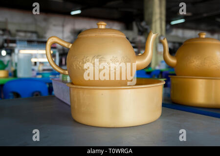 A gold, plastic hand washing set at a cafe table in Kota Kinabalu, Sabah, Borneo, Malaysia. Stock Photo