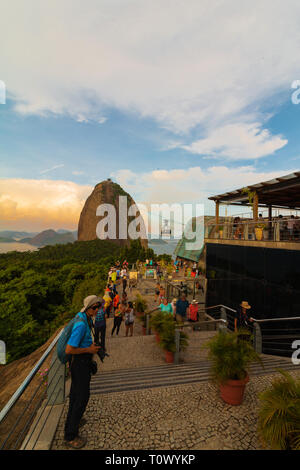 Tourists visiting the Sugar Loaf mountain in Rio de Janeiro at sunset. Stock Photo