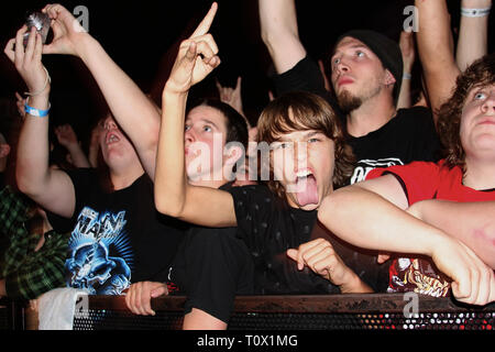 Front row fans are shown rocking out during a 'live' concert performance. Stock Photo