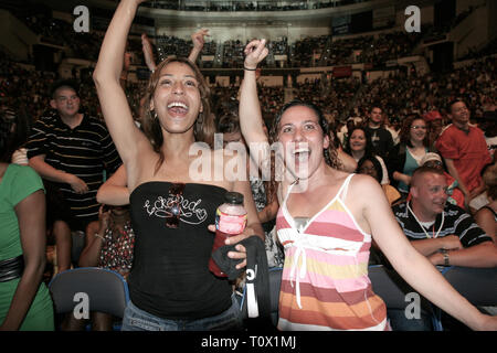 Front row concert fans are shown dancing to the music during a 'live' performance. Stock Photo