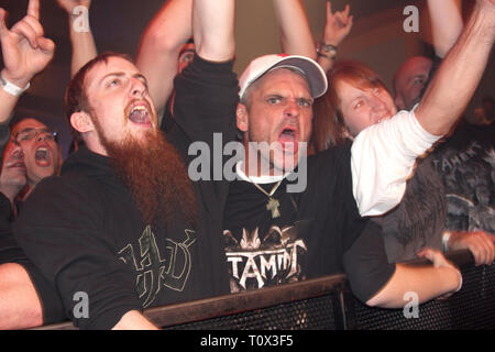 Front row heavy metal fans are shown rockin hard during a 'live' concert performance. Stock Photo