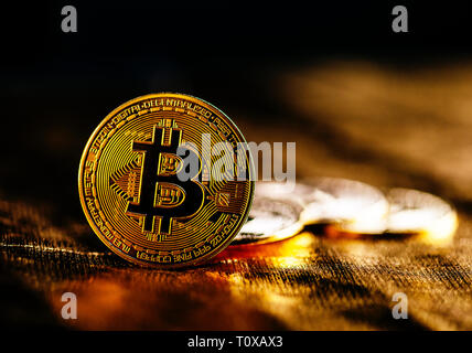 Closeup of golden bitcoin BTC cryptocurrency over black and gold background. Virtual money and blockchain concept. Stock Photo