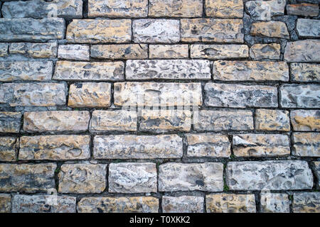 Grey stone road close up. Fragment of an ancient walkway paved with cobblestones. Example of pavement from the past. Block paving in old times. Histor Stock Photo