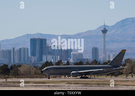 Colombian Air Force Multi-Mission Transport  Tanker Jupiter 767 taxies during Red Flag 19-2 on  the flightline at Nellis Air Force Base, Nev., with the  Las Vegas skyline in the background March 14,  2019. The Colombian Air Force solely refueled the  U.S. Navy EA-18G Growlers during the exercise. The  U.S Air Force’s refueling aircraft participating in Red  Flag 19-2 were boom operated air-to-air refueling  systems and the Growlers utilize a drogue air-to-air  refueling system, which the Colombian MMTT  Jupiter 767 provides. (U.S. Air Force photo by Tech. Sgt. Angela Ruiz) Stock Photo