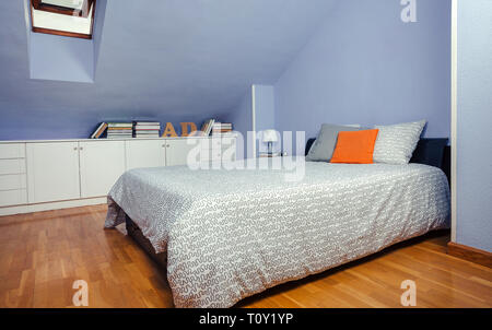 Bedroom in an attic with double bed Stock Photo