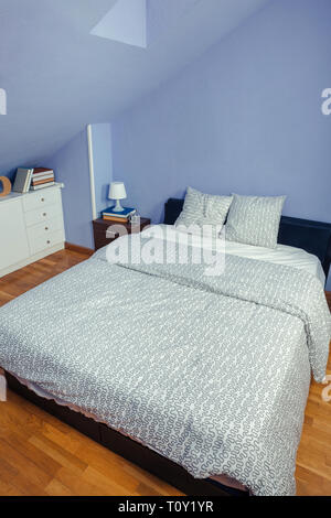 Bedroom in an attic with double bed Stock Photo