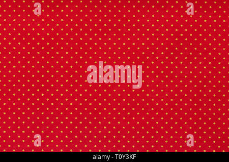 Still life close up detail of a bright red piece of paper with aligned white polka dots and texture.  Stock Photo