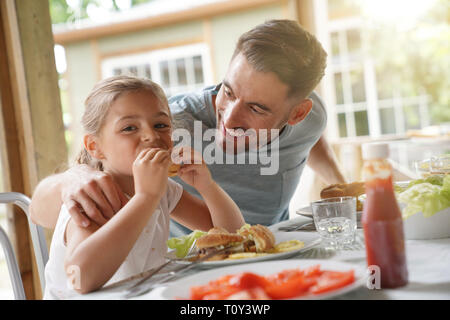 Portrait of man with little girl eating lunch together