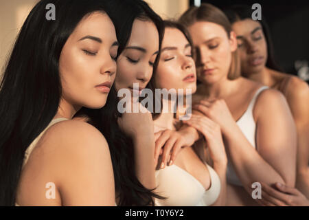 selective focus of five multicultural girls with closed eyes in sunlight Stock Photo