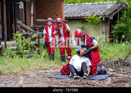 Rescue team helping injured woman. Stock Photo