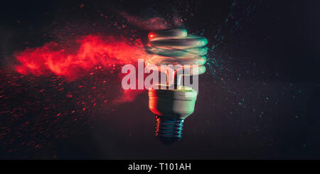 Studio photography of the real explosion of a low-consumption light bulb shot at the exact moment of the impact with a bullet. Gases and glasses are v Stock Photo