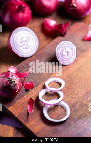Slices of shallot onions and red onions over wood cutting board Stock Photo