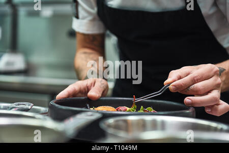 https://l450v.alamy.com/450v/t1049m/creative-cooking-cropped-image-of-chef-hands-garnishing-pasta-carbonara-in-a-restaurant-kitchen-food-decoration-t1049m.jpg