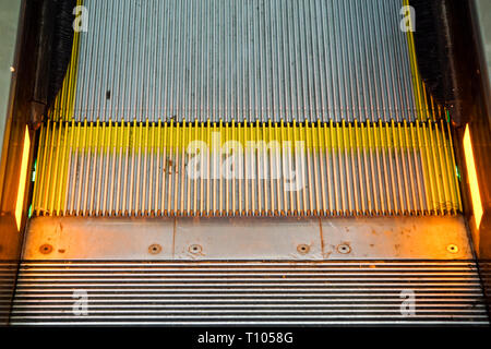 Escalator in Community Mall, Shopping Center. Moving up staircase. electric escalator. Close up to escalators. Close up floor platform. yellow bands.  Stock Photo