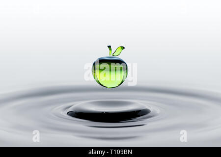 Rain drop in shape of green apple falling on water surface Stock Photo