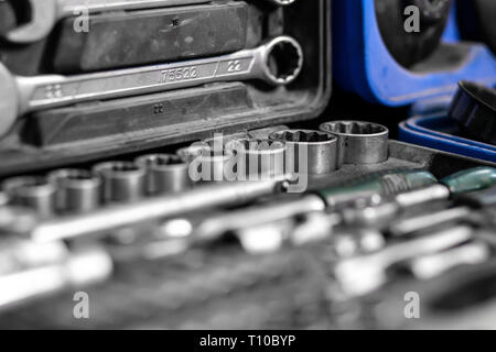 Flat Lay metal tools: wrenches, ratchet, a set of interchangeable heads of different sizes and other tools are in the tool box, a top view. Close-up C Stock Photo