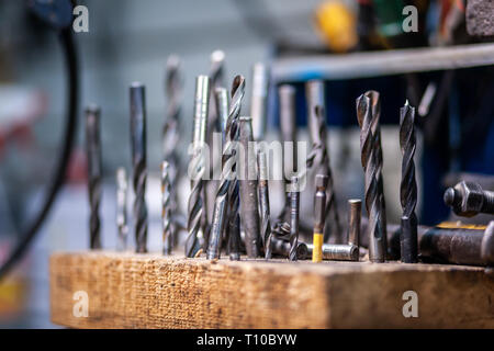 Flat Lay metal tools: A set of interchangeable metal drills of different sizes and other tools are in the tool box, side view. Close-up Carpenter's To Stock Photo