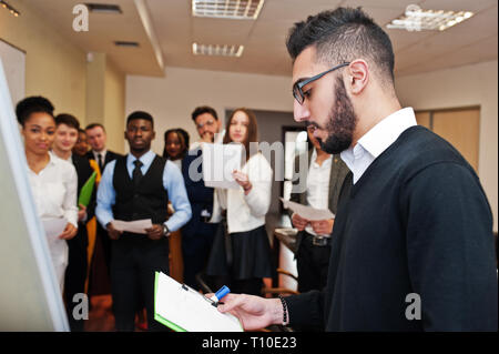 Arabian business coach presenting report standing near whiteboard ...