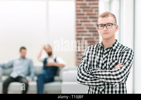 serious young man standing in spacious office Stock Photo