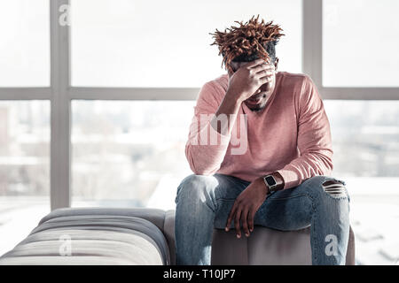 Delighted international male being deep in thoughts Stock Photo