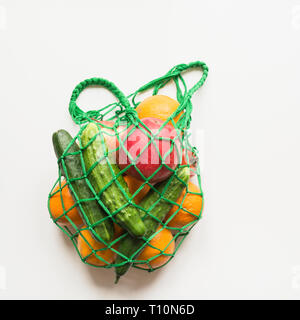 Zero waste concept. Green shopping textile bag with fresh orange and vegetables. Space for text. View from above. Stock Photo