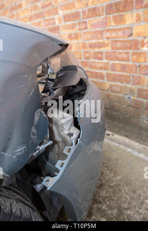 Car crash. Silver vehicle in front end collision. Damage to bumper/ wheel arch/ headlight. Brick work backgroun. UK