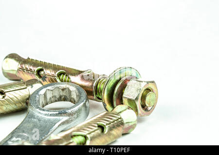 Close up steel expansion anchors bolts and wrench isolate on white background. Stock Photo