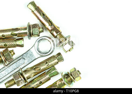 Close up steel expansion anchors bolts and wrench isolate on white background. Stock Photo