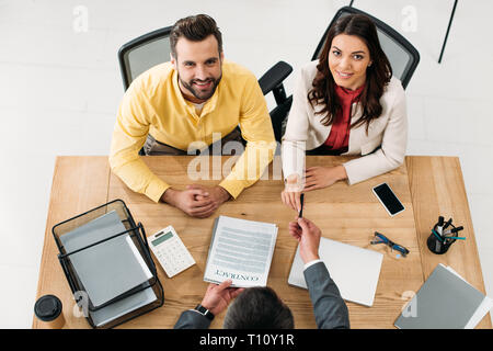 high angle view of advisor giving contract to investors at table in office Stock Photo