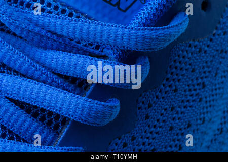 Fragment of a blue sneaker with drawstring macro.Sneaker texture Stock Photo
