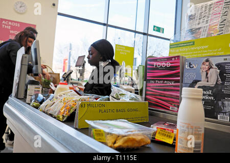 Waitrose supermarket employee young black woman working on till at checkout counter job people buying food in London England UK  KATHY DEWITT Stock Photo