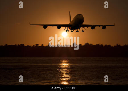 3D rendering of a commercial airplane landing / take off at sunset Stock Photo