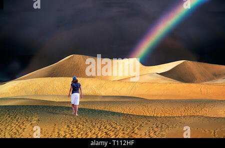 A rare evening rain shower and rainbow at Mesquite Flat Sand Dunes in Death Valley National Park, California Stock Photo
