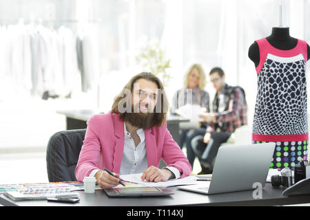 smiling fashion Designer at the table in a modern Studio Stock Photo