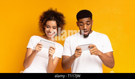 Emotional african-american man and woman watching videos online Stock Photo
