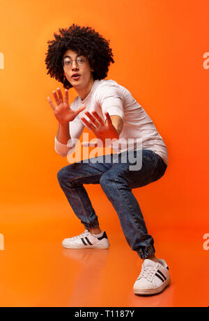 Emotional black curly guy standing in attack position Stock Photo