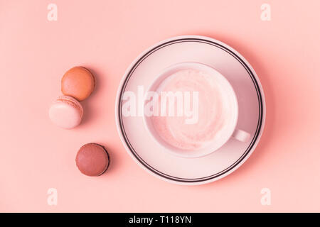 Cup of coffee with macaroons on pastel background, flat lay. Stock Photo