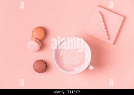 Cup of coffee with macaroons on pastel background, flat lay. Stock Photo