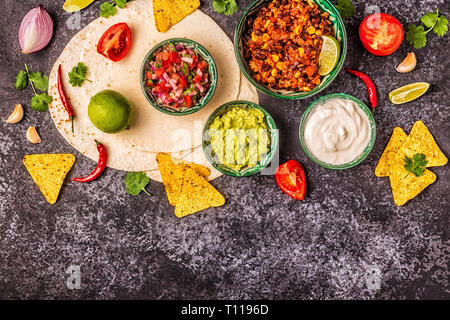 Mexican food concept: tortillas, nachos with guacamole, salsa, chili con carne, top view. Stock Photo